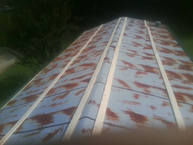 Rusted metal roof panels with new wood purlins before replacement — Storm Damage Roof Repair in Lilburn by Roofing Brothers