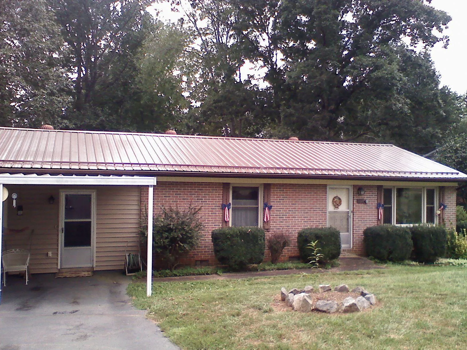 Bronze metal roof and carport on a brick ranch home — Roof Repair work by our crew in Lilburn