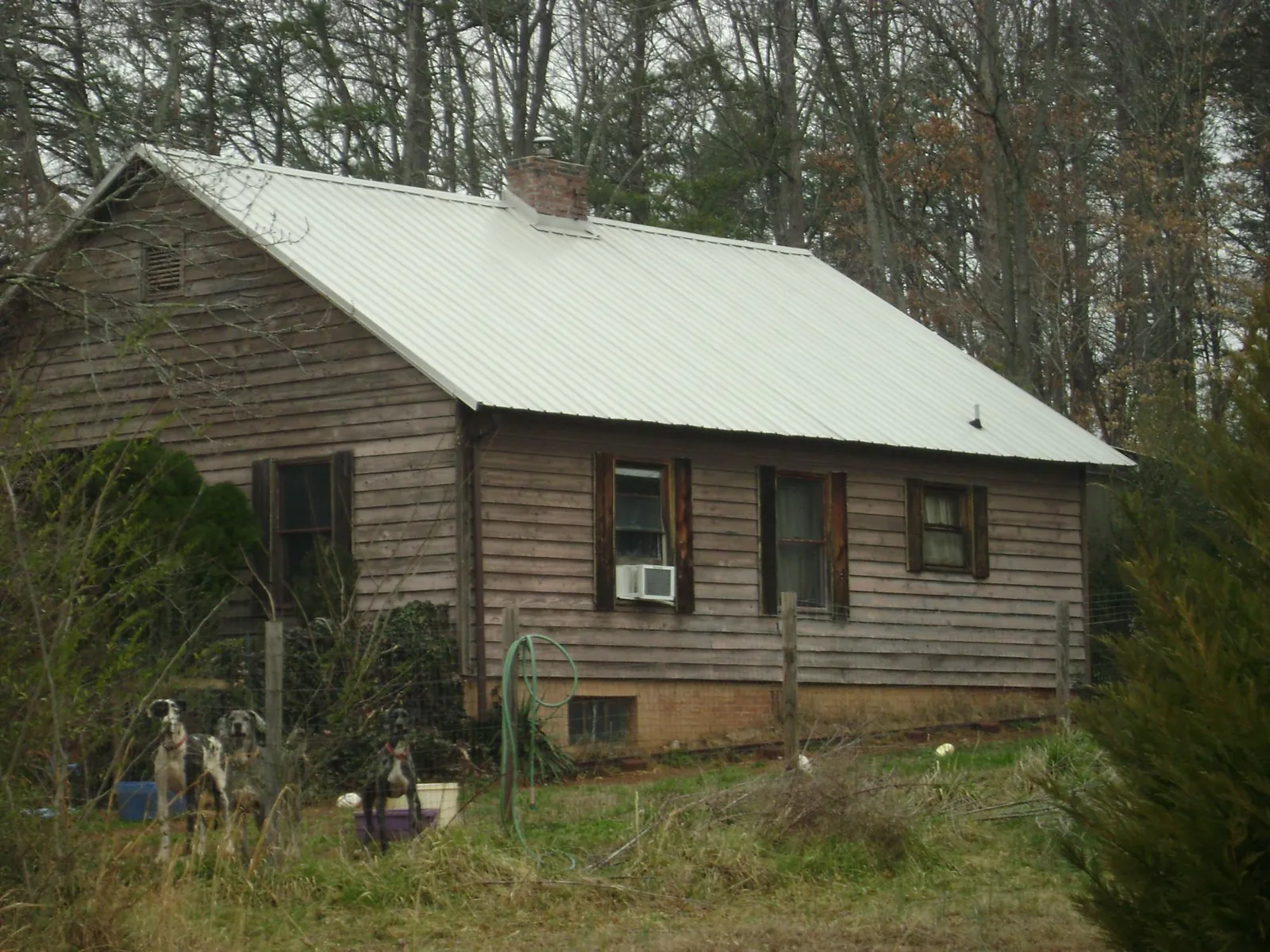 White metal roof on an old wood sided farmhouse, from a Asphalt Shingle Roof Repair job in Lilburn